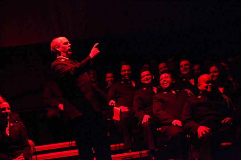 a man is giving a lecture in front of a group of people