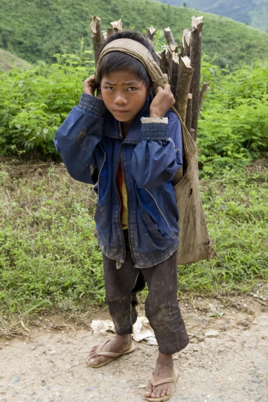 a young asian boy holds on to his ears