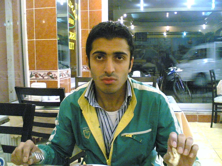 a young man eating a bowl of soup and holding a spoon