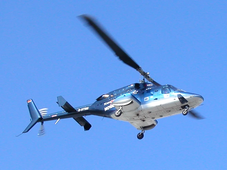 a helicopter flying in the air during a sunny day