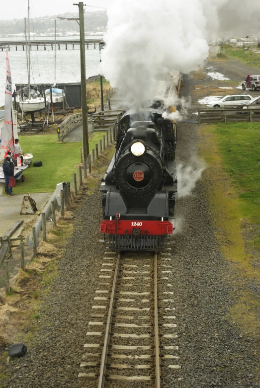 a steam train moving along the track and leaving