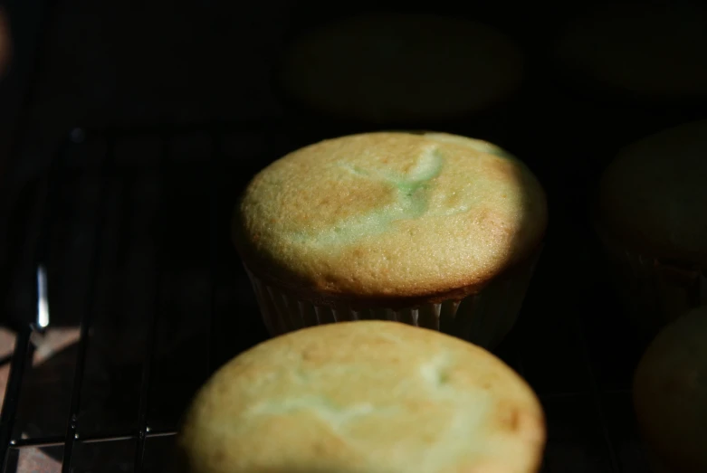 muffins are cooking in the oven on a rack