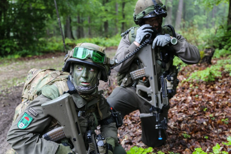 two soldiers are taking position in the woods