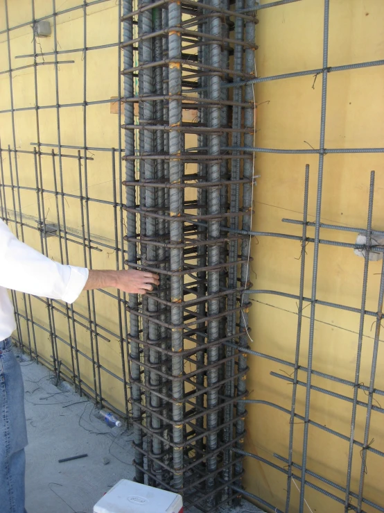 a construction worker pointing to some metal rods