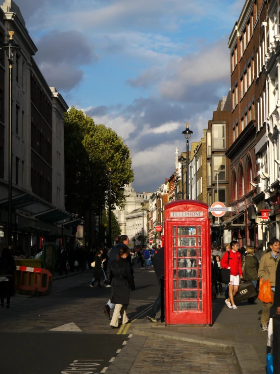 some people walking down a street next to some tall buildings