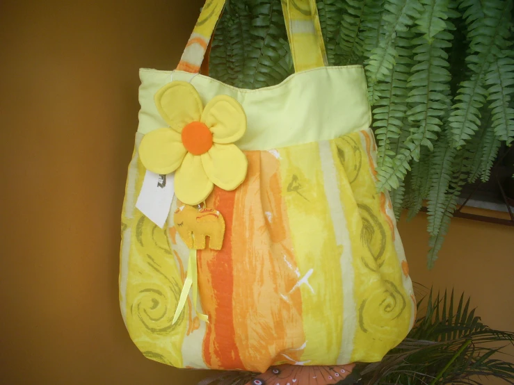 an orange flower is attached to a handbag