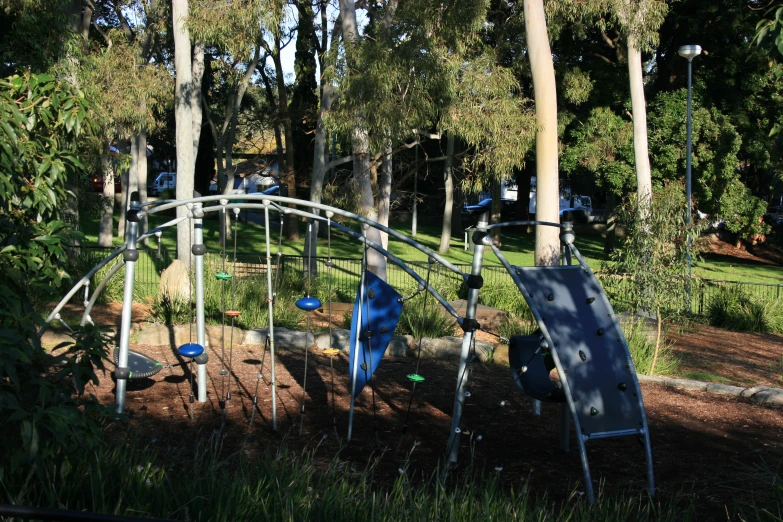 a group of blue slides under trees in a park