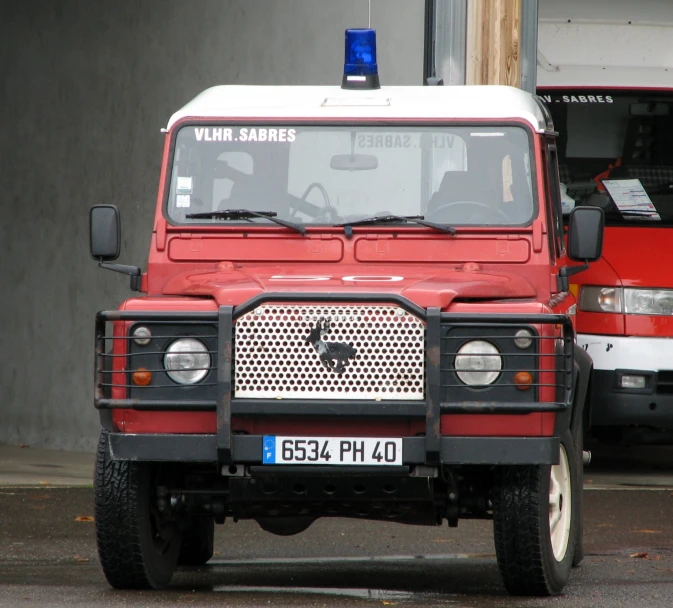 an older red truck parked next to a red firetruck