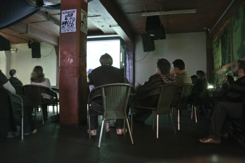 several people sitting around a table and some drinking at the bar