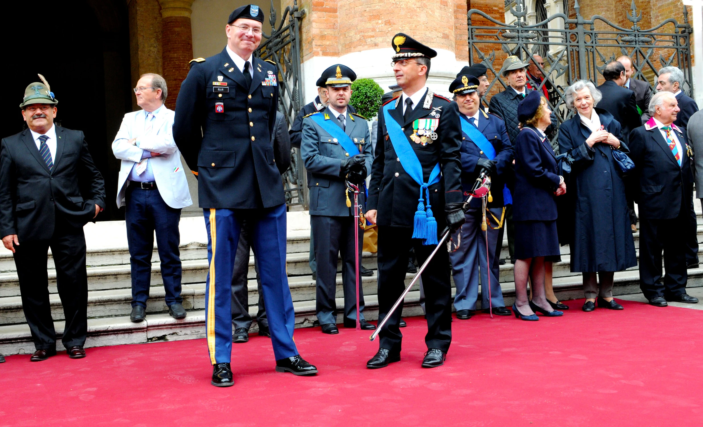 two officers and an official at the ceremony with people in formal dress