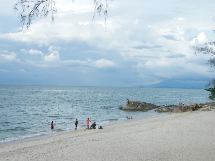 many people in red and white shirts at the edge of water