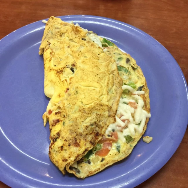 an omelet on a plate sitting on top of a table