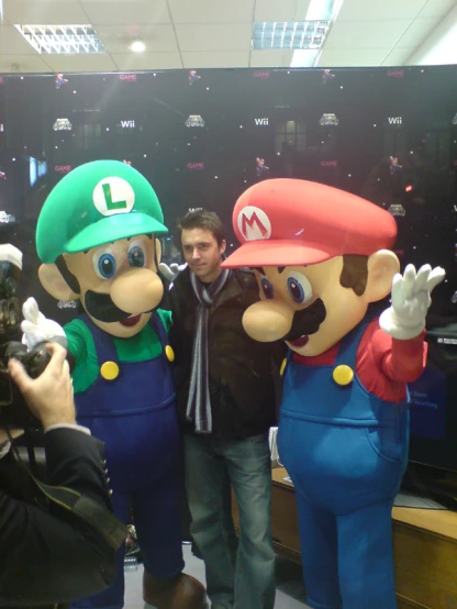 two large puppets, one person in nintendo characters and the other on a camera