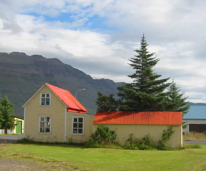 a red roof on the house in the distance