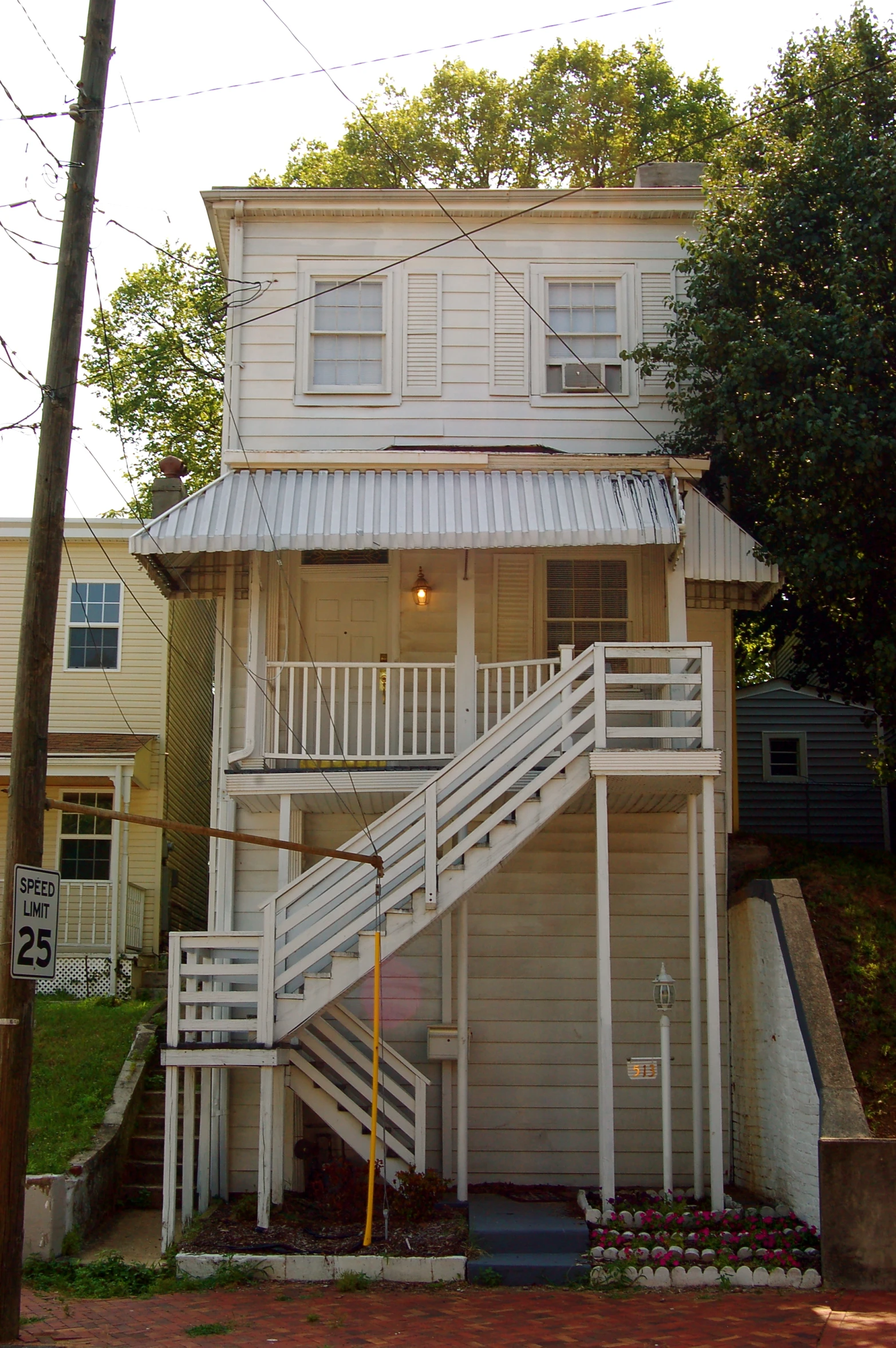 a two story house with white staircase leading up the side