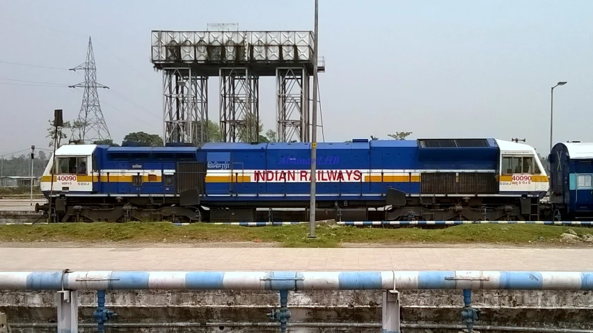 two trains parked on the tracks beside a fence