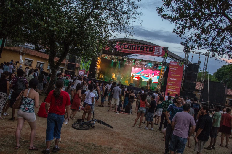 a crowded festival is lit up with people standing in front