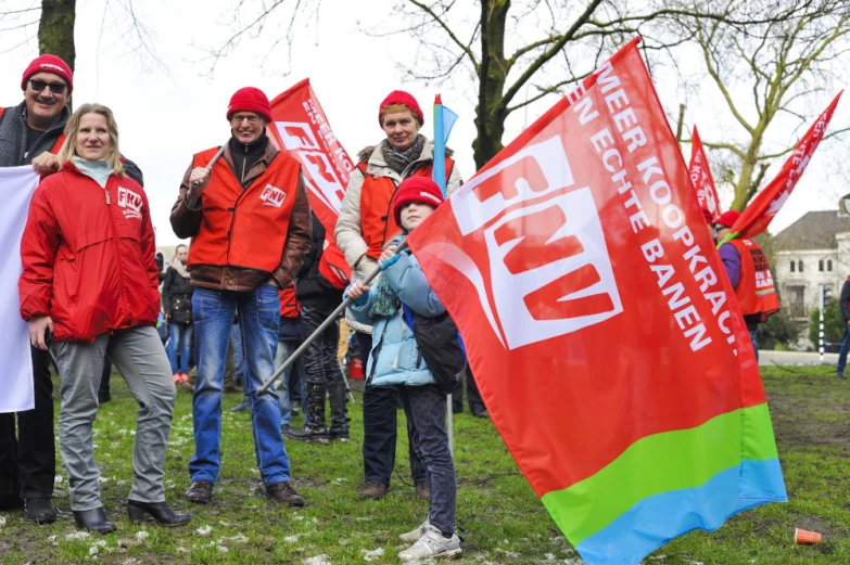 a group of people standing in a field holding up red and green flags