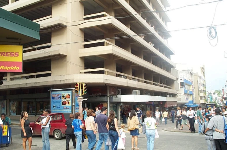 some people are standing around some buildings on the street