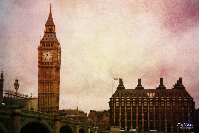 a clock tower towering over several buildings on the other side of a body of water