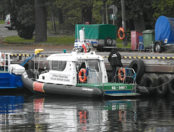 a small tug boat is docked next to a large barge