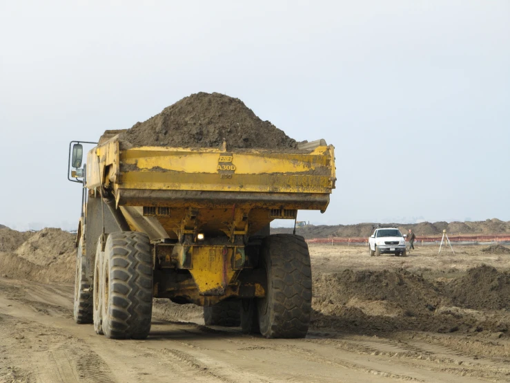 an excavator truck traveling down a dirt road