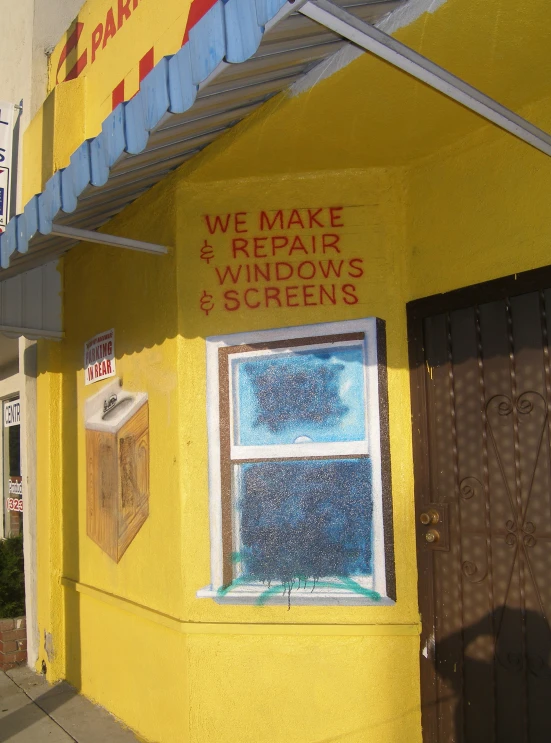 a yellow building has a sign and window on it