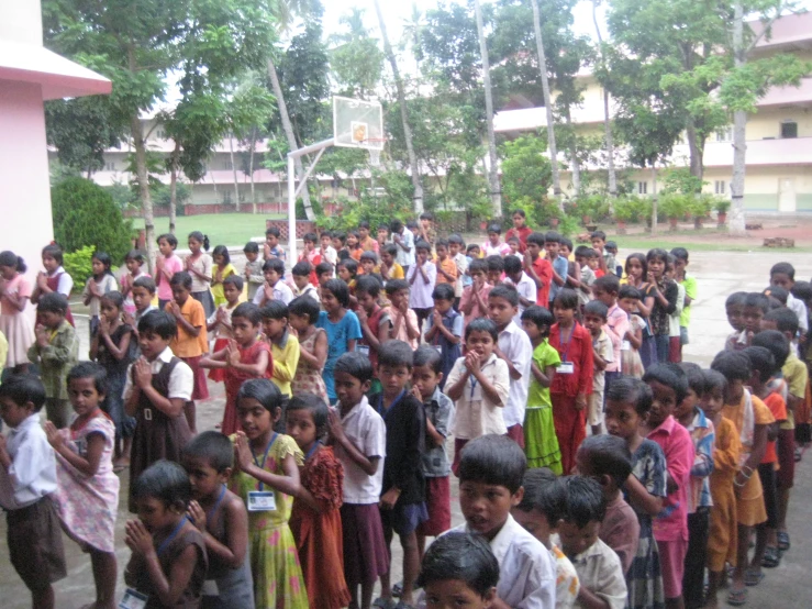 a large group of children and adults standing on the street
