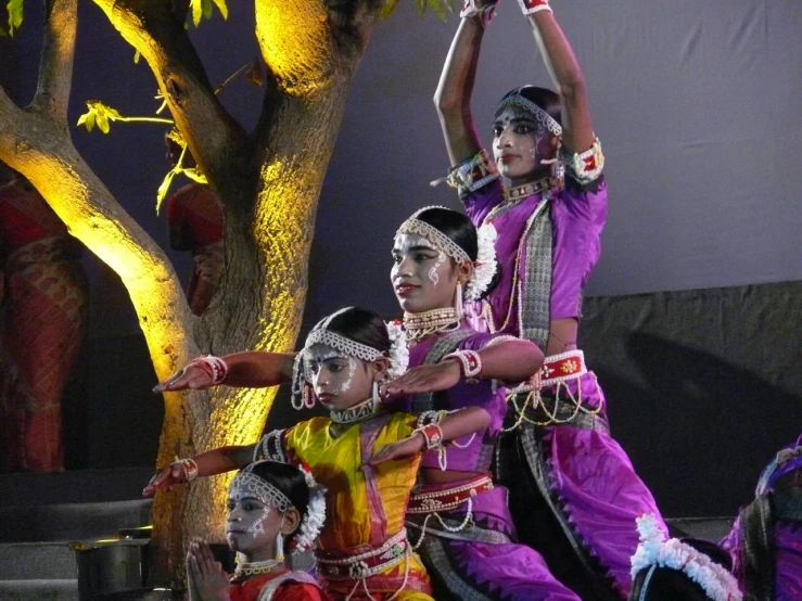 a group of women dance on the stage