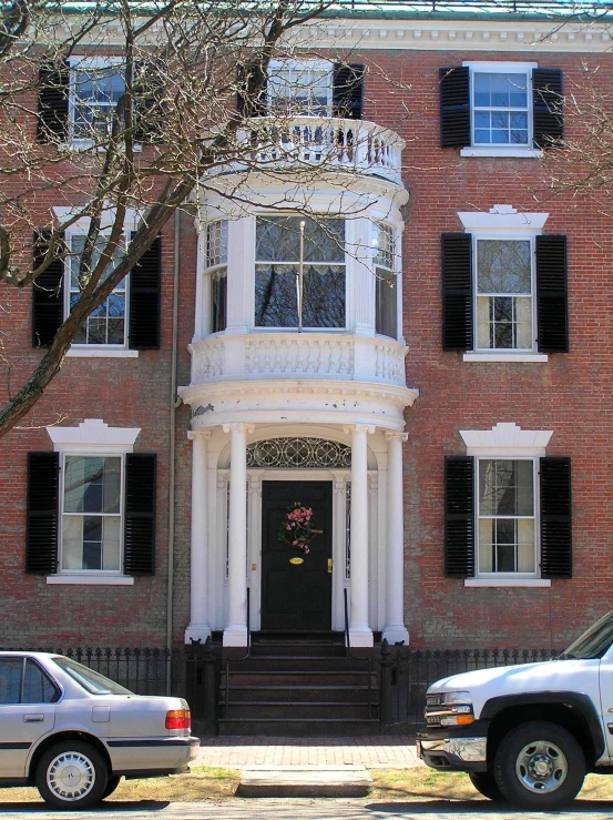 two cars are parked on the side of the street next to a large brick building