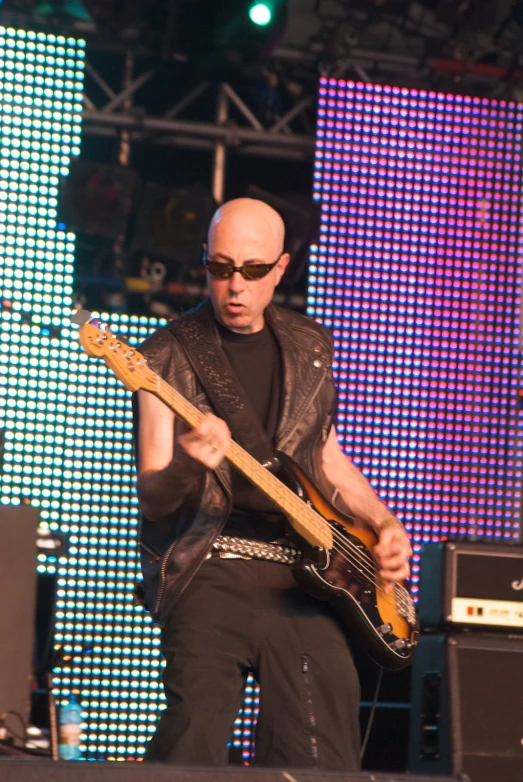 a man plays guitar while wearing shades