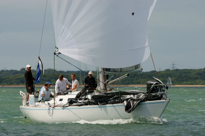 people sitting on a sailboat in the middle of the water