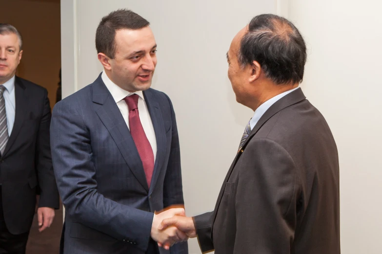 a group of men talking and shaking hands