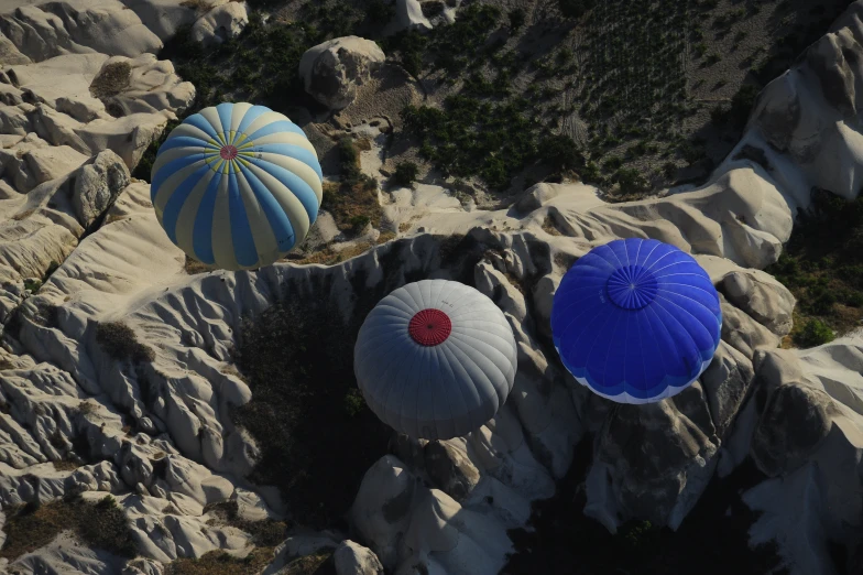 three balloons sitting on the rock formation in the desert