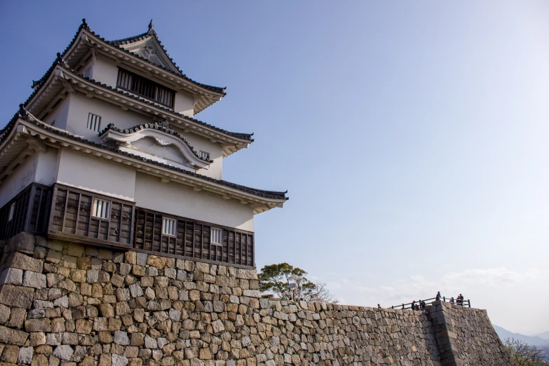 a tall white building sitting on the side of a stone wall