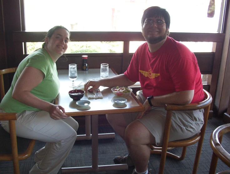 the man and woman are sitting down at a table