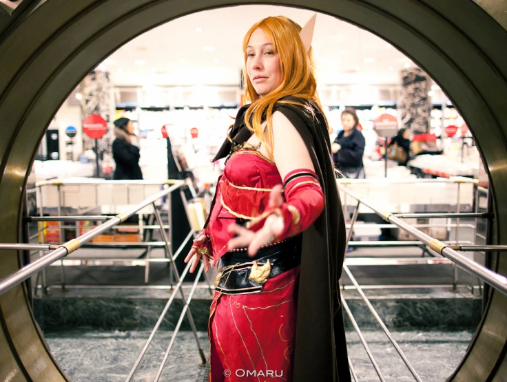 a woman in costume standing in an outside metal structure