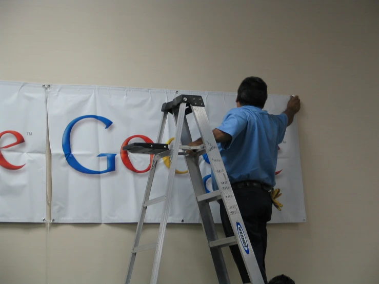 an asian man is painting the google logo