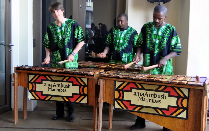 a group of men play musical instruments on stage