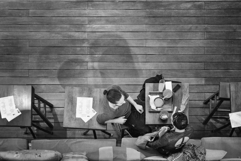three people sitting on a bench looking at papers