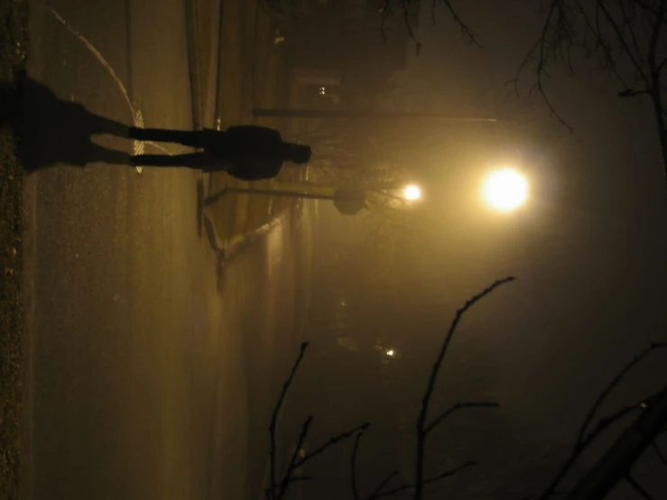 a person in hoodie walking down street at night