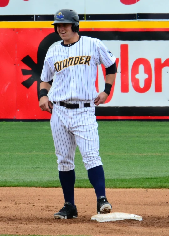 there is a man standing on a baseball field wearing a uniform