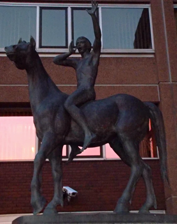 a statue that is standing next to a building