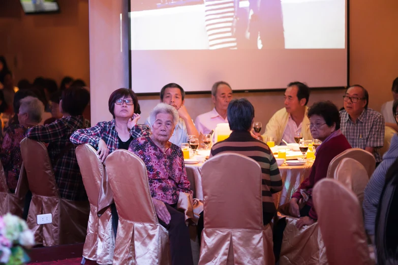 people sit at tables with food and wine for a dinner