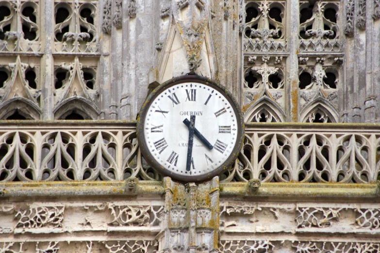 there is a large clock hanging in front of a building