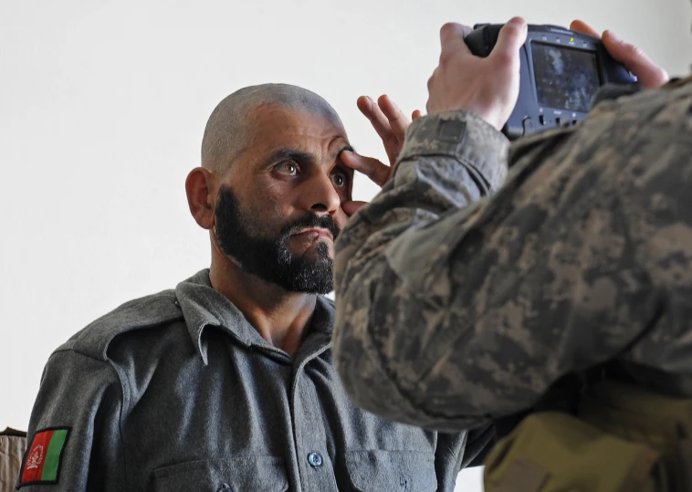 a man standing near a person wearing a uniform