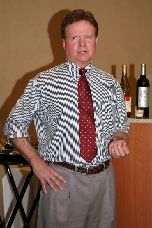 a man is standing next to wine bottles