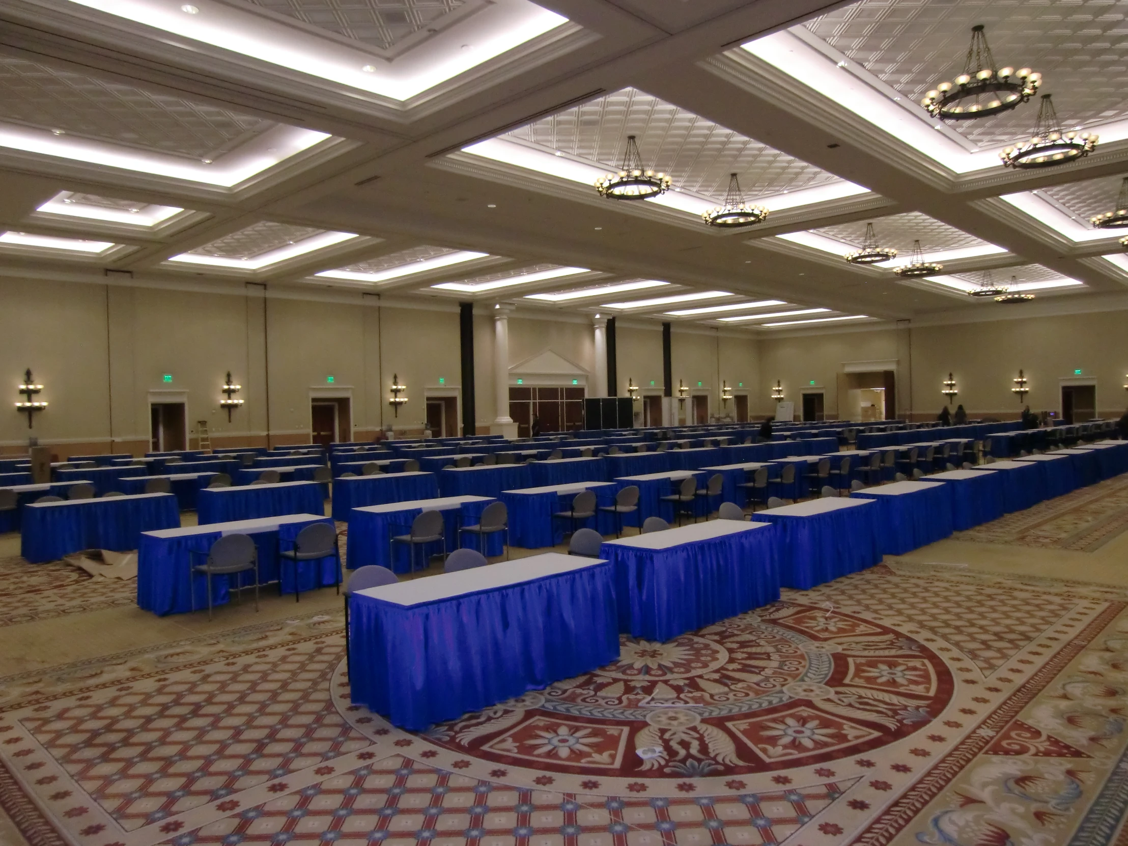 tables and chairs in a room with white ceiling lighting