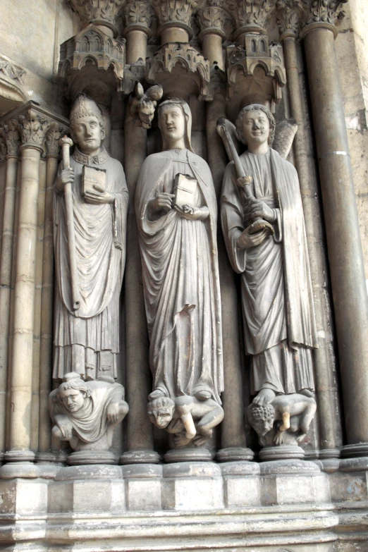 sculptures of saints are standing in front of an ornate wall