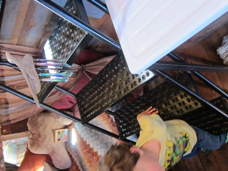 the young child is climbing a three tiered ladder in his room